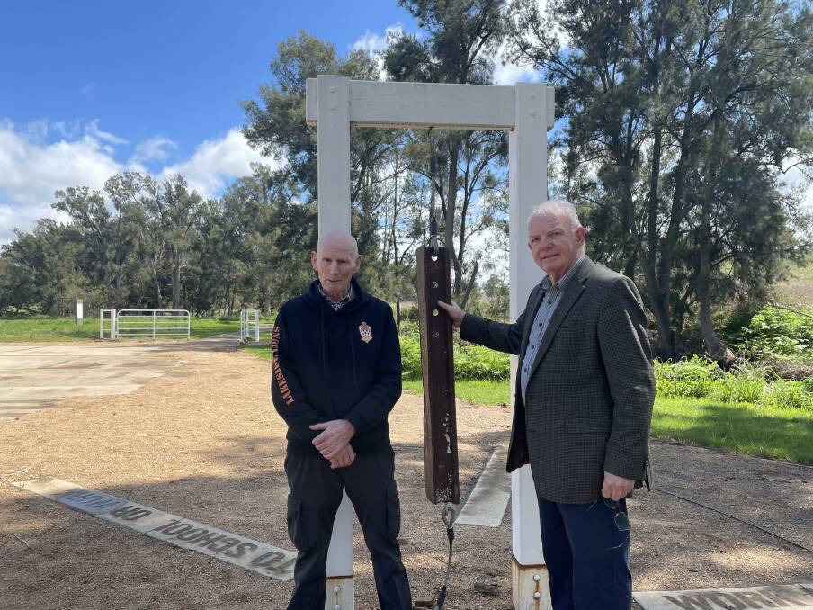 Fairbridge Farm School students Derek Moriarty (left) and David Hill (right) at the Fairbridge Park near Molong. The old school bell - made from disused railway line - pays tribute to victims of the school. 