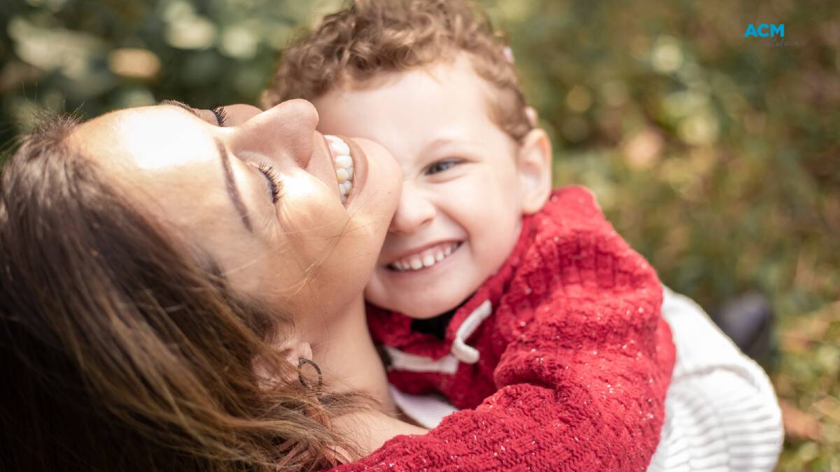 A mother and son laugh and hug. Picture via Canva