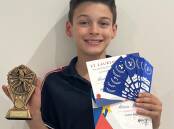 Morgan McMillan with his winning trophy, ribbons and certificates from the St Laurences carnival.