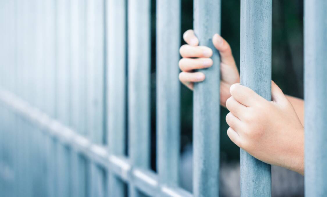 A file picture of a child's hands behind bars. A 13-year-old boy has faced Orange Children's Court for breaching his bail. File picture 