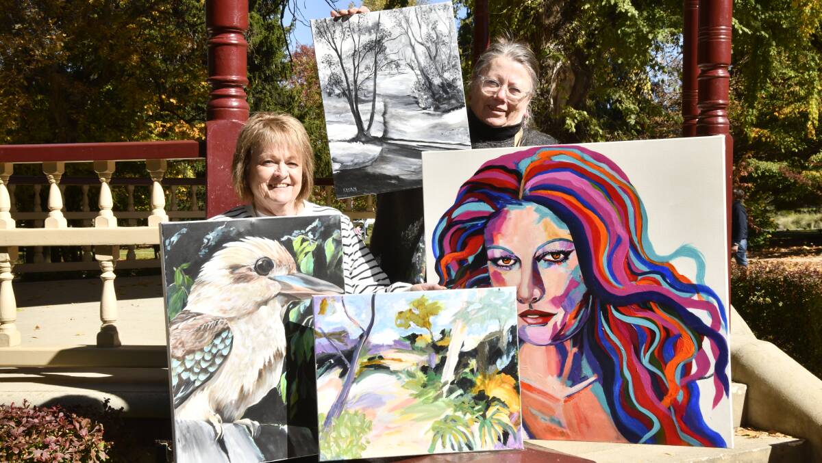 Art from the Heart members Penny Fulmer and Lynnie Lambell with some of the paintings that will be for sale. Picture by Jude Keogh.