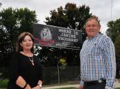Rhonda Griffin and Peter Rogers standing near the Janine Vaughan billboard in 2023, before her image was covered. The billboard has since been handed back to the community and will now be used to promote community events.