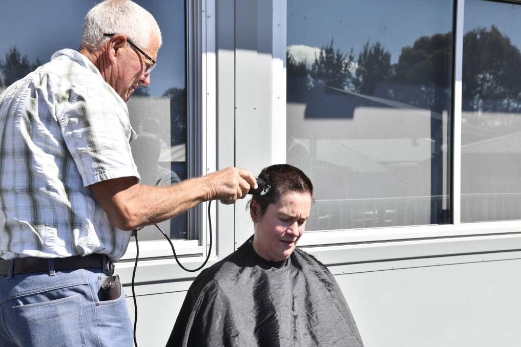 Emma Jeffrey getting her head shaved by Robert Littlefield. Picture by Carla Freedman