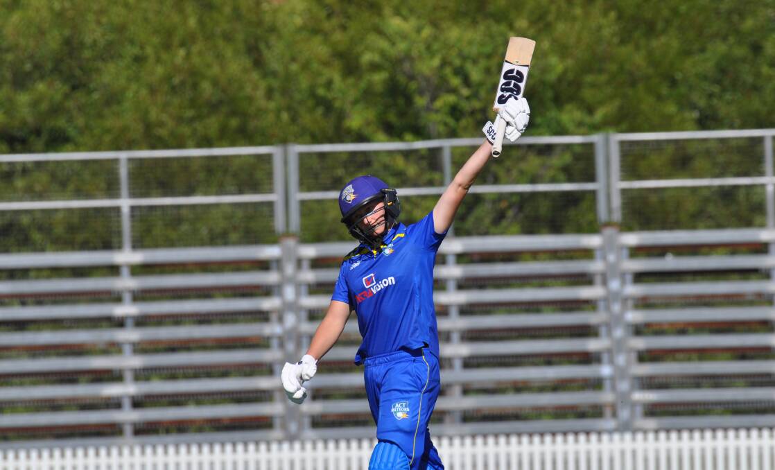 Zoe Cooke raises the bat after her hundred. Picture by Lachlan Harper 