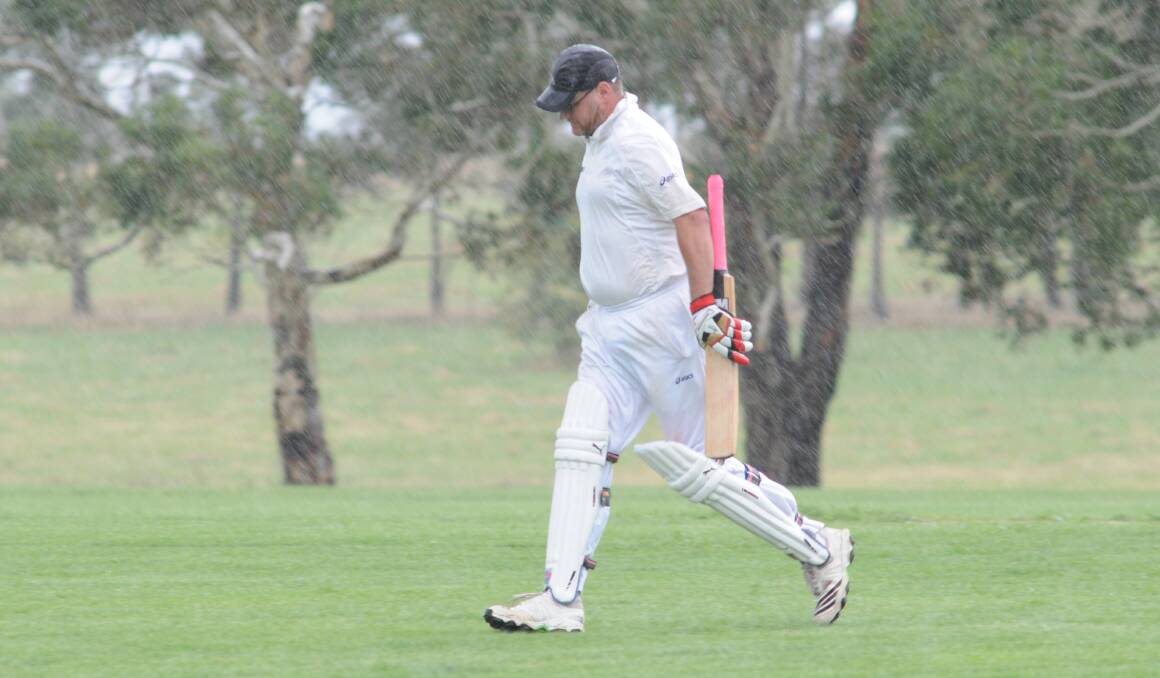 STOP PLAY: Cricket players including Jeff Chapman (pictured) were forced to stop play at Waratah Sports Ground yesterday morning as a result of heavy rainfall. Photo: JUDE KEOGH 		                 0110tahscricket5
