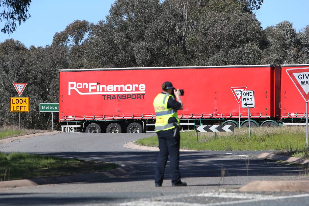 A Ron Finemore Transport truck drives past the scene on Friday morning. Picture by Blair Thomson